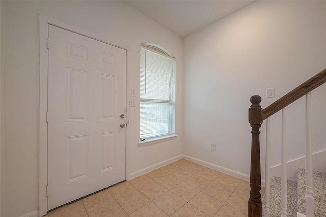 entrance foyer with stairway, light tile patterned floors, and baseboards