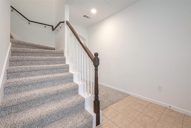 stairs featuring tile patterned floors, baseboards, and carpet