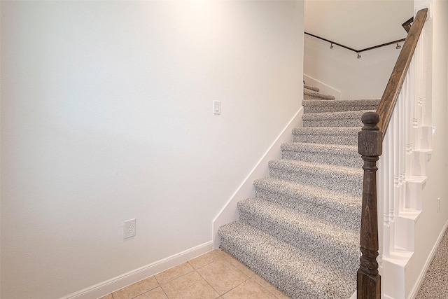 stairway featuring tile patterned floors and baseboards