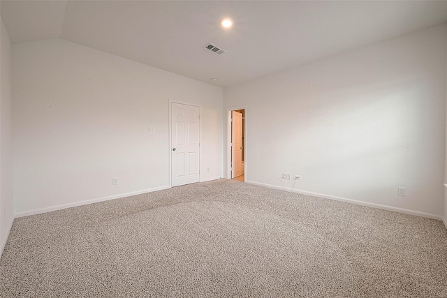 empty room featuring light colored carpet, baseboards, and lofted ceiling