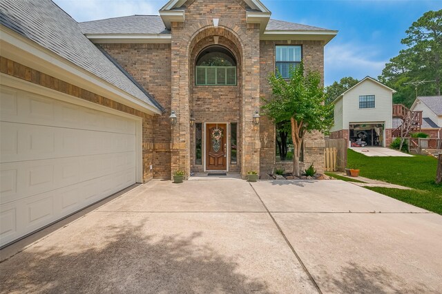 14844 Pollux Dr, Willis, TX 77318 - view of front of property featuring brick siding, driveway, a shingled roof, and a front lawn