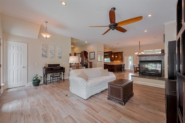 14844 Pollux Dr, Willis, TX 77318 - living room featuring a ceiling fan, a tiled fireplace, light wood-style flooring, recessed lighting, and crown molding