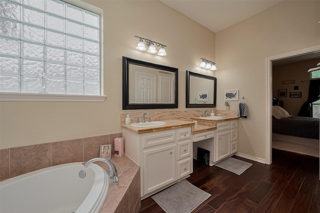 14844 Pollux Dr, Willis, TX 77318 - ensuite bathroom featuring a bath, double vanity, and wood finished floors