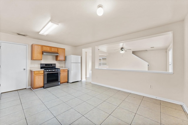 15427 Western Skies Dr, Houston, TX 77086 - kitchen featuring stainless steel gas range, freestanding refrigerator, under cabinet range hood, light countertops, and a ceiling fan