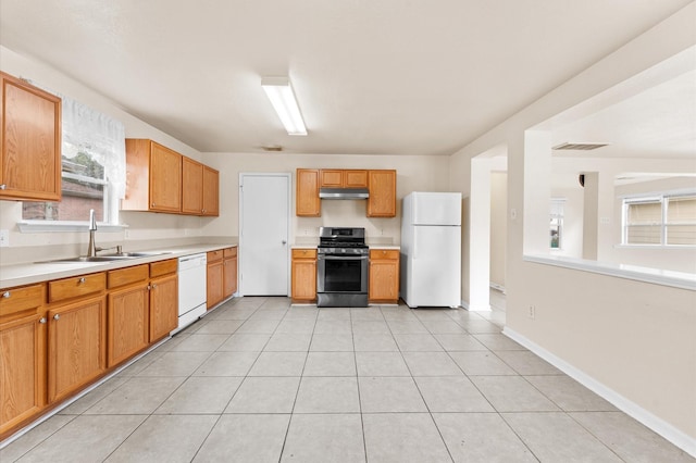 15427 Western Skies Dr, Houston, TX 77086 - kitchen featuring white appliances, a sink, under cabinet range hood, light countertops, and baseboards
