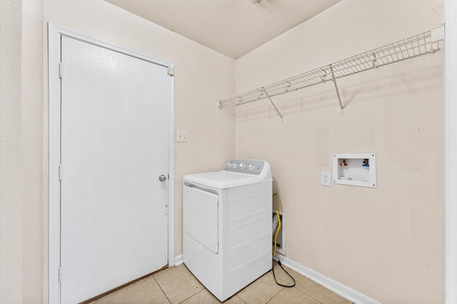 15427 Western Skies Dr, Houston, TX 77086 - laundry area with washer / dryer, light tile patterned floors, and baseboards