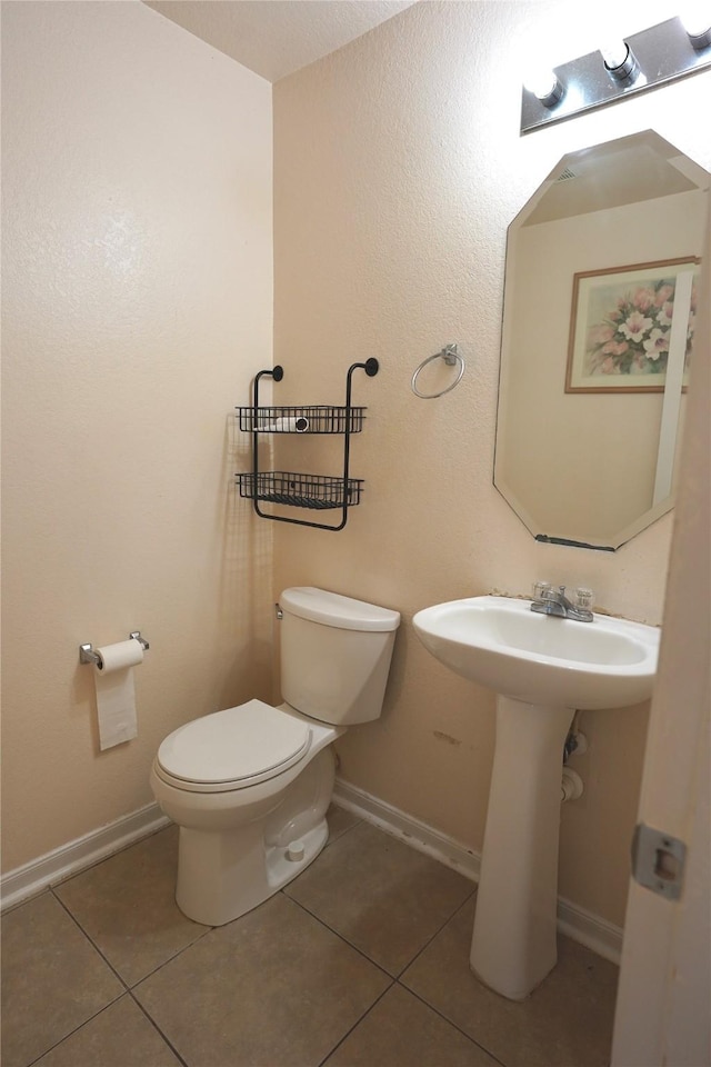 15427 Western Skies Dr, Houston, TX 77086 - half bath featuring tile patterned floors, toilet, and baseboards