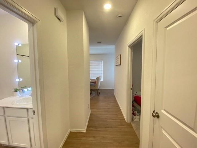 1926 Barrett Gables Dr, Crosby, TX 77532 - corridor with light wood finished floors, a sink, and baseboards