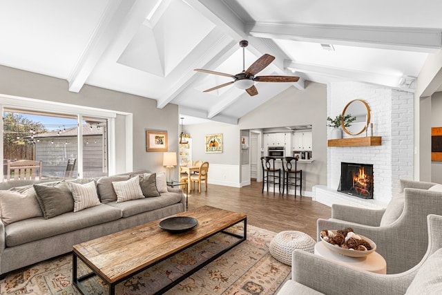 living room with a brick fireplace, wood finished floors, ceiling fan, and baseboards