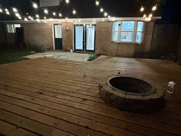 11106 Sagevalley Dr N, Houston, TX 77089 - deck at night featuring an outdoor fire pit