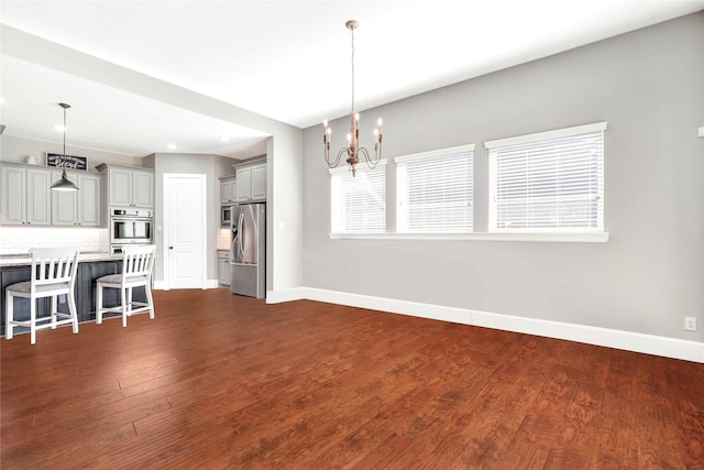30622 Indigo Falls Dr, Brookshire, TX 77423 - kitchen with stainless steel appliances, baseboards, a breakfast bar area, light countertops, and a chandelier