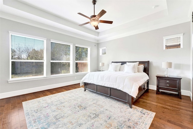 30622 Indigo Falls Dr, Brookshire, TX 77423 - bedroom featuring a tray ceiling, dark wood-style flooring, baseboards, and ceiling fan