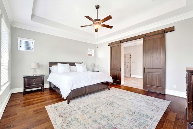 30622 Indigo Falls Dr, Brookshire, TX 77423 - bedroom with a raised ceiling, a barn door, dark wood-style floors, baseboards, and crown molding