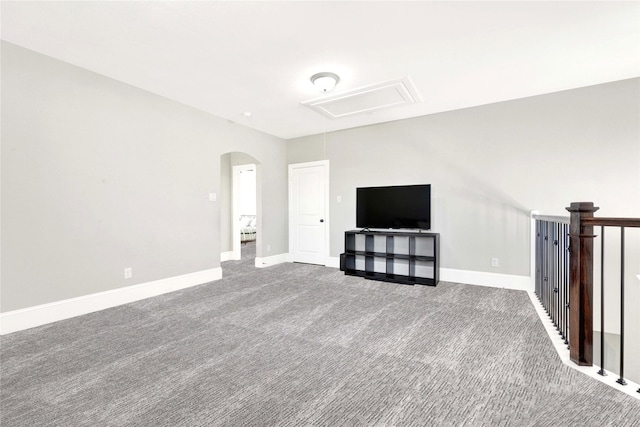 30622 Indigo Falls Dr, Brookshire, TX 77423 - unfurnished living room featuring attic access, arched walkways, carpet flooring, and baseboards
