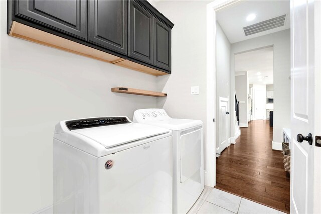 30622 Indigo Falls Dr, Brookshire, TX 77423 - washroom with washing machine and clothes dryer, cabinet space, and light tile patterned floors