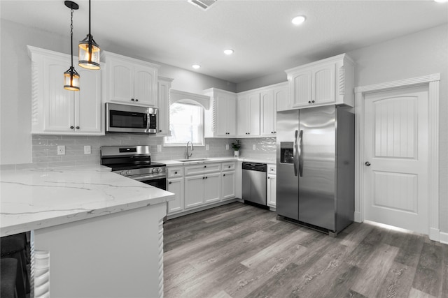 206 San Luis Blvd, Freeport, TX 77541 - kitchen featuring appliances with stainless steel finishes, a sink, white cabinetry, tasteful backsplash, and recessed lighting