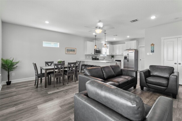 206 San Luis Blvd, Freeport, TX 77541 - living area featuring recessed lighting, dark wood-type flooring, ceiling fan, and baseboards