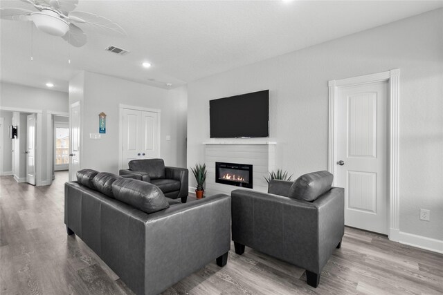 206 San Luis Blvd, Freeport, TX 77541 - living room with a ceiling fan, recessed lighting, wood finished floors, a glass covered fireplace, and baseboards