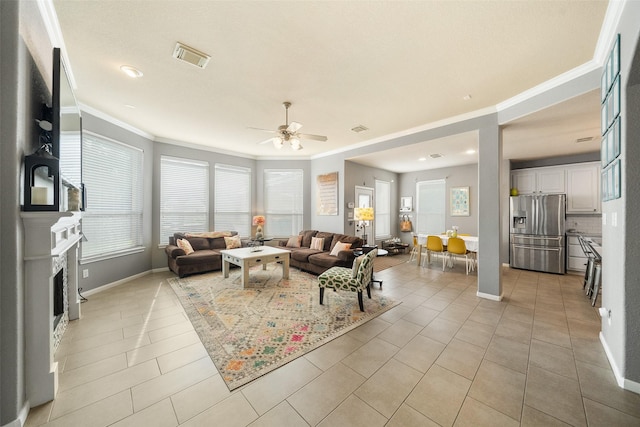 2510 Eagle Post Dr, Conroe, TX 77304 - living room with crown molding, ceiling fan, light tile patterned floors, baseboards, and a fireplace