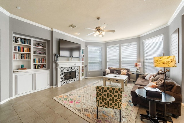 2510 Eagle Post Dr, Conroe, TX 77304 - tiled living area with crown molding, a ceiling fan, a tile fireplace, built in features, and baseboards
