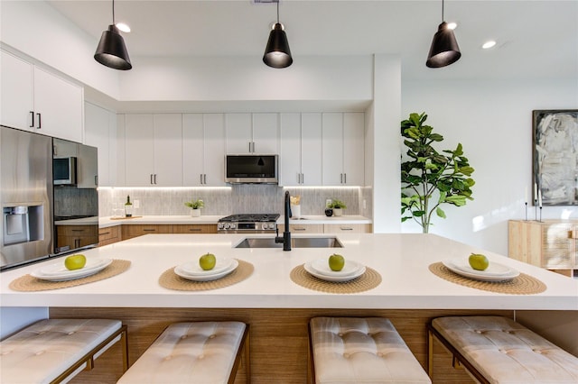 2704 Fox St, Houston, TX 77003 - kitchen with appliances with stainless steel finishes, a sink, light countertops, tasteful backsplash, and pendant lighting