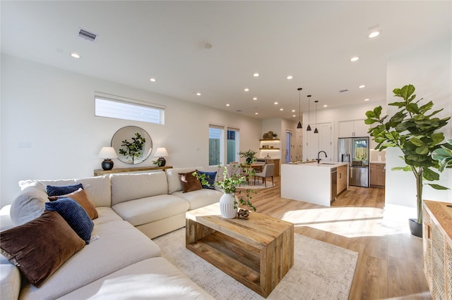 2704 Fox St, Houston, TX 77003 - living area featuring light wood-style flooring, recessed lighting, and healthy amount of natural light