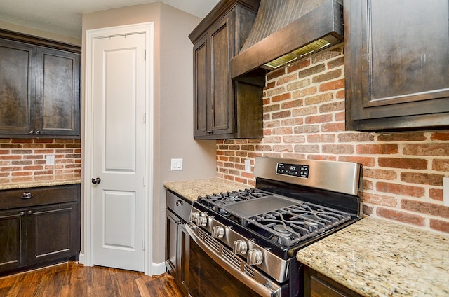 705 Seydler St, East Bernard, TX 77435 - kitchen with stainless steel range with gas stovetop, dark brown cabinets, dark wood-style floors, and light stone counters