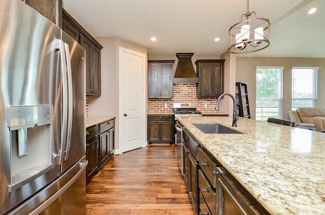 705 Seydler St, East Bernard, TX 77435 - kitchen featuring appliances with stainless steel finishes, a sink, dark wood-style flooring, dark brown cabinetry, and custom range hood