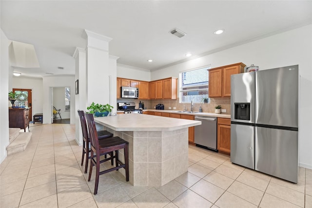 10826 Redstone Ct, Missouri City, TX 77459 - kitchen featuring stainless steel appliances, light countertops, light tile patterned floors, tasteful backsplash, and crown molding