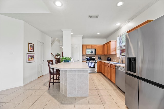 10826 Redstone Ct, Missouri City, TX 77459 - kitchen with stainless steel appliances, a sink, light countertops, crown molding, and tasteful backsplash