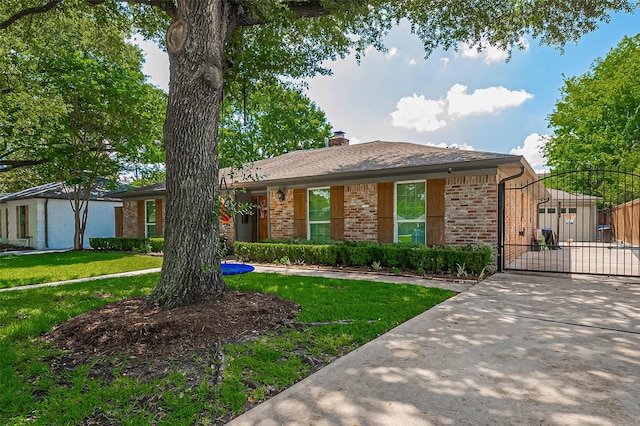 ranch-style house with brick siding, a gate, a front yard, and concrete driveway