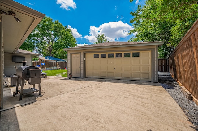 detached garage featuring fence and cooling unit