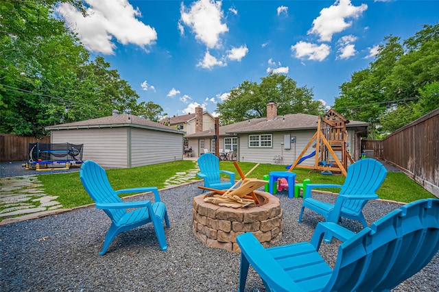 view of patio with an outdoor fire pit, a trampoline, and a playground