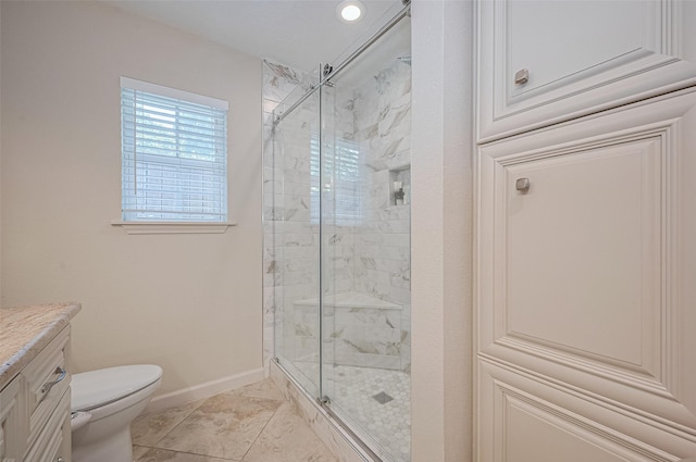 full bathroom with a stall shower, baseboards, toilet, and vanity