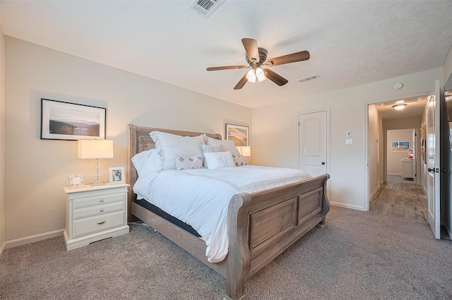 bedroom featuring light colored carpet, baseboards, and a ceiling fan