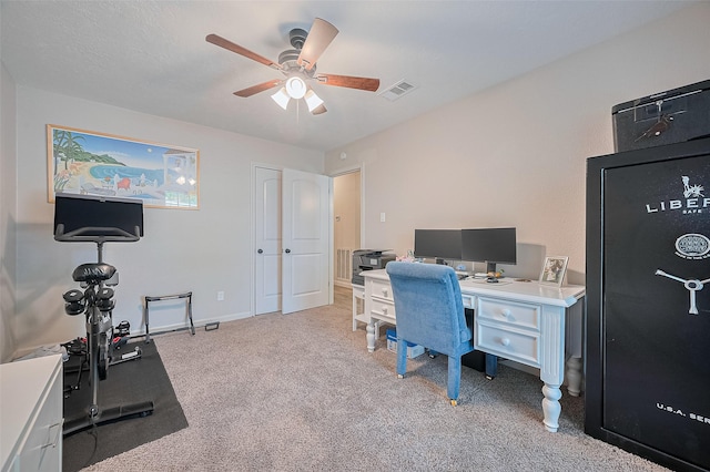 office area featuring light carpet, a ceiling fan, and baseboards