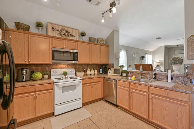2910 Meridian Bay Ln, Dickinson, TX 77539 - kitchen featuring stainless steel appliances, a sink, tasteful backsplash, light tile patterned floors, and lofted ceiling