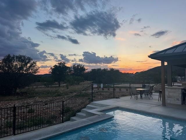 1463 Mountain Valley Dr, Concan, TX 78838 - pool at dusk featuring a patio and fence