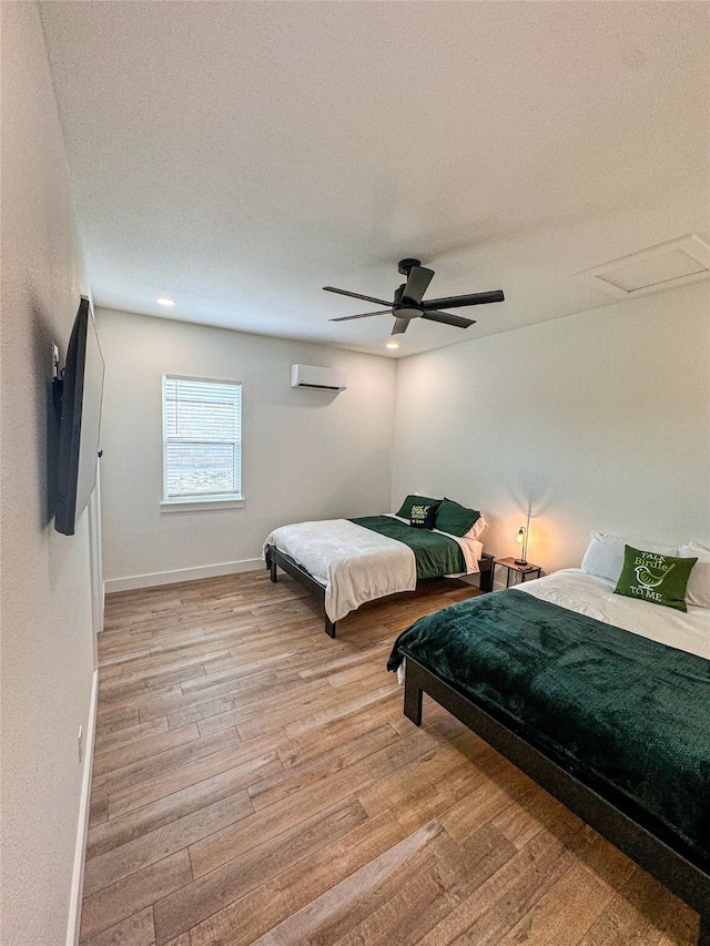 1463 Mountain Valley Dr, Concan, TX 78838 - bedroom featuring light wood-style floors, baseboards, ceiling fan, and an AC wall unit