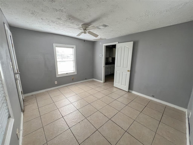 1600 Ash St, Baytown, TX 77520 - unfurnished bedroom with light tile patterned floors, a textured ceiling, baseboards, and ceiling fan