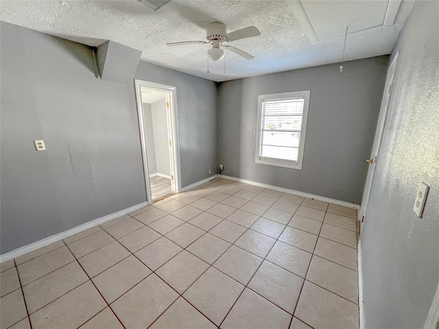 1600 Ash St, Baytown, TX 77520 - empty room with light tile patterned floors, ceiling fan, attic access, a textured ceiling, and baseboards