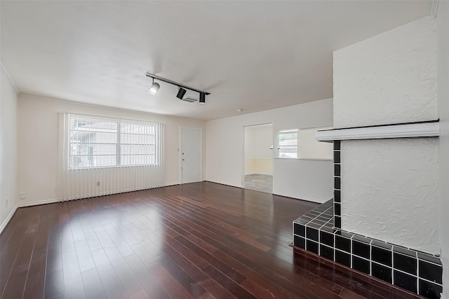 7827 Braesdale Ln, Houston, TX 77071 - unfurnished living room with rail lighting, hardwood / wood-style floors, and baseboards
