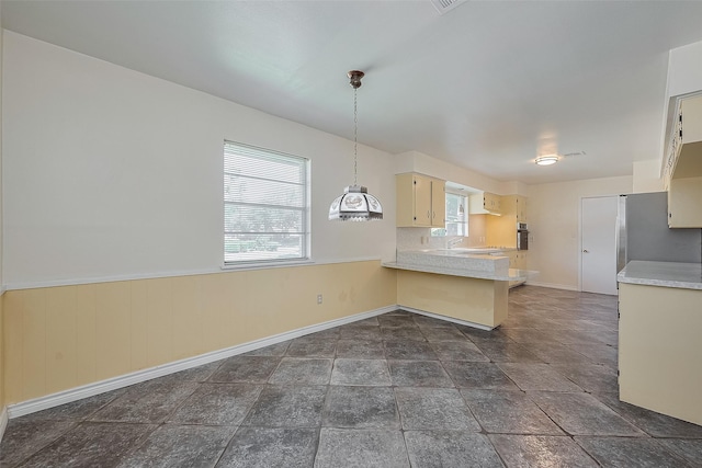 7827 Braesdale Ln, Houston, TX 77071 - kitchen featuring light countertops, a peninsula, oven, baseboards, and a wainscoted wall