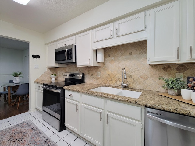 1201 Bering Dr Unit 44, Houston, TX 77057 - kitchen featuring appliances with stainless steel finishes, a sink, and white cabinetry