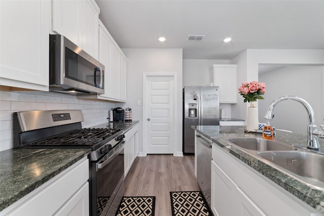 7258 Allendale Arbor Ct, Cypress, TX 77433 - kitchen featuring appliances with stainless steel finishes, a sink, white cabinetry, light wood-style floors, and recessed lighting