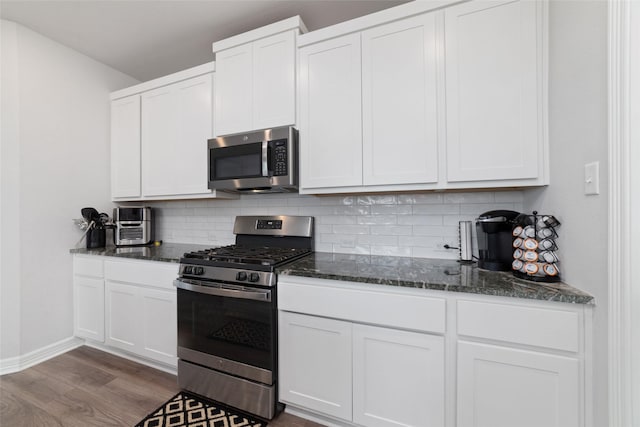 7258 Allendale Arbor Ct, Cypress, TX 77433 - kitchen with appliances with stainless steel finishes, dark wood finished floors, backsplash, white cabinetry, and dark stone countertops