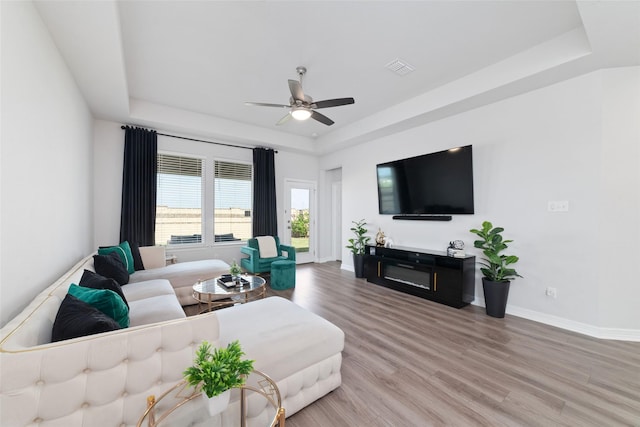 7258 Allendale Arbor Ct, Cypress, TX 77433 - living room featuring a tray ceiling, wood finished floors, a ceiling fan, and baseboards