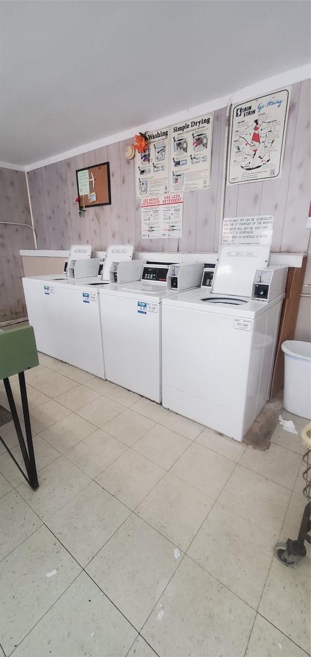 8941 Gaylord St Unit 211, Houston, TX 77024 - shared laundry featuring wooden walls, light tile patterned floors, and independent washer and dryer