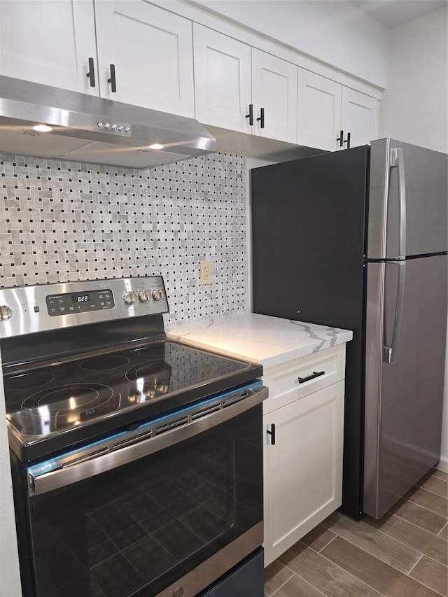 8941 Gaylord St Unit 211, Houston, TX 77024 - kitchen with appliances with stainless steel finishes, under cabinet range hood, white cabinets, dark wood-style flooring, and light stone counters