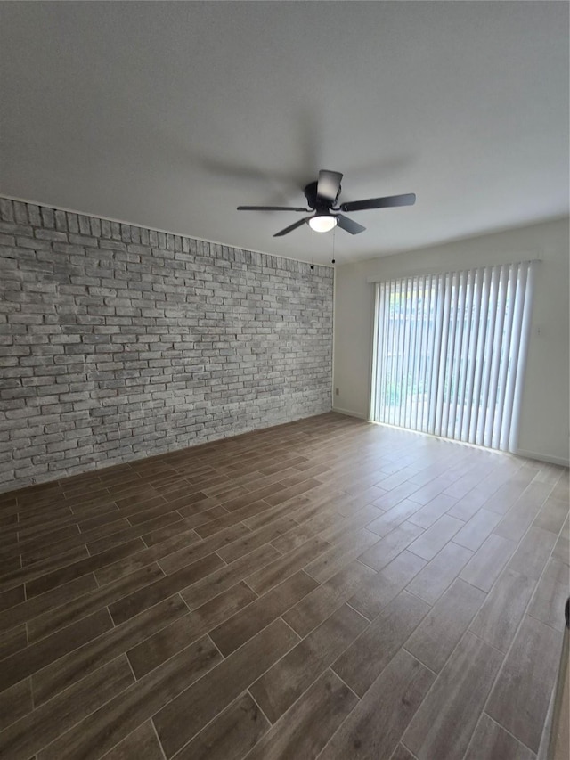 8941 Gaylord St Unit 211, Houston, TX 77024 - spare room with brick wall, a ceiling fan, and dark wood-type flooring